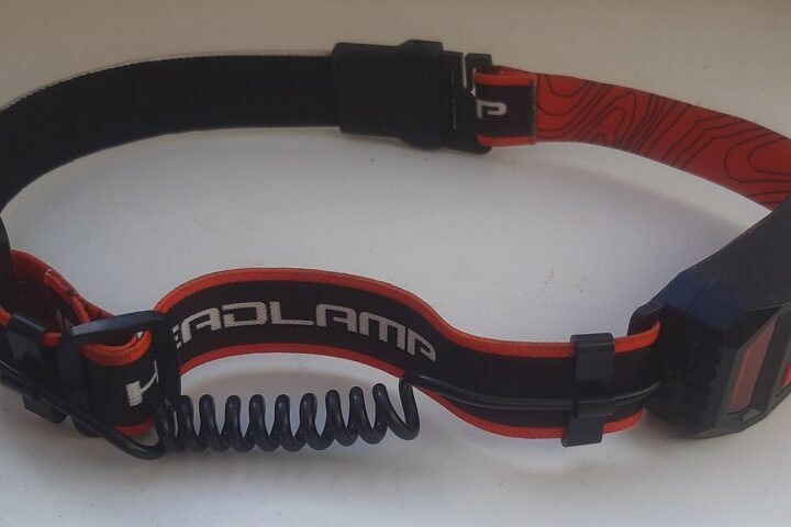 LED headlamp with a head strap and a coiled cable