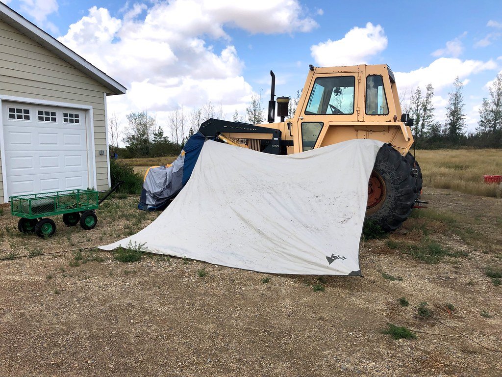 A tent hung over a tractor to dry