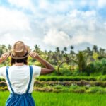 Smiling woman tourist in a straw hat with a mountain behind her in Bali