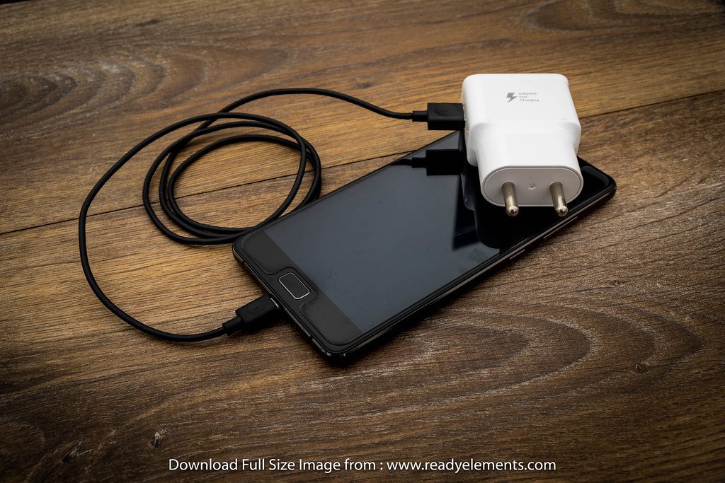 A black mobile phone battery charger with a black USB cable